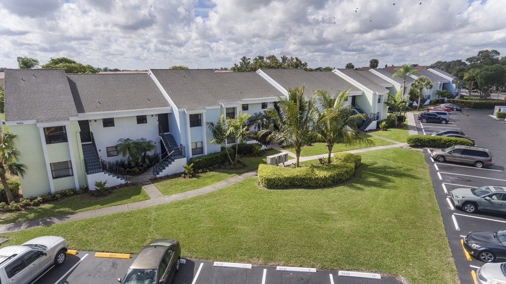 A parking lot with cars and a building in the background.